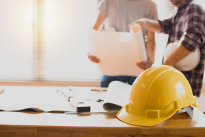 contractors looking at paper with safety helmet on desk